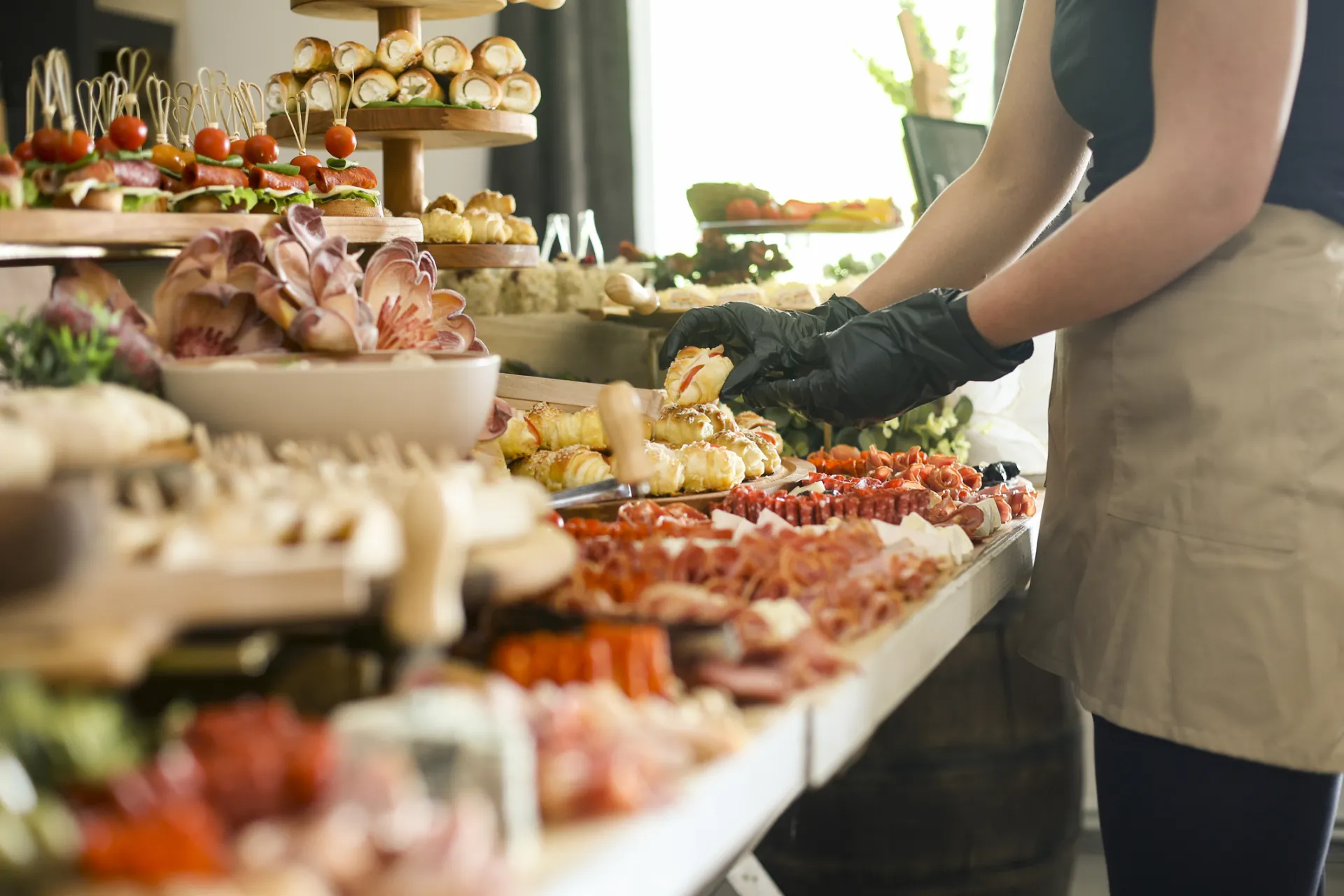Eine Frau richtet einen Catering Tisch an.