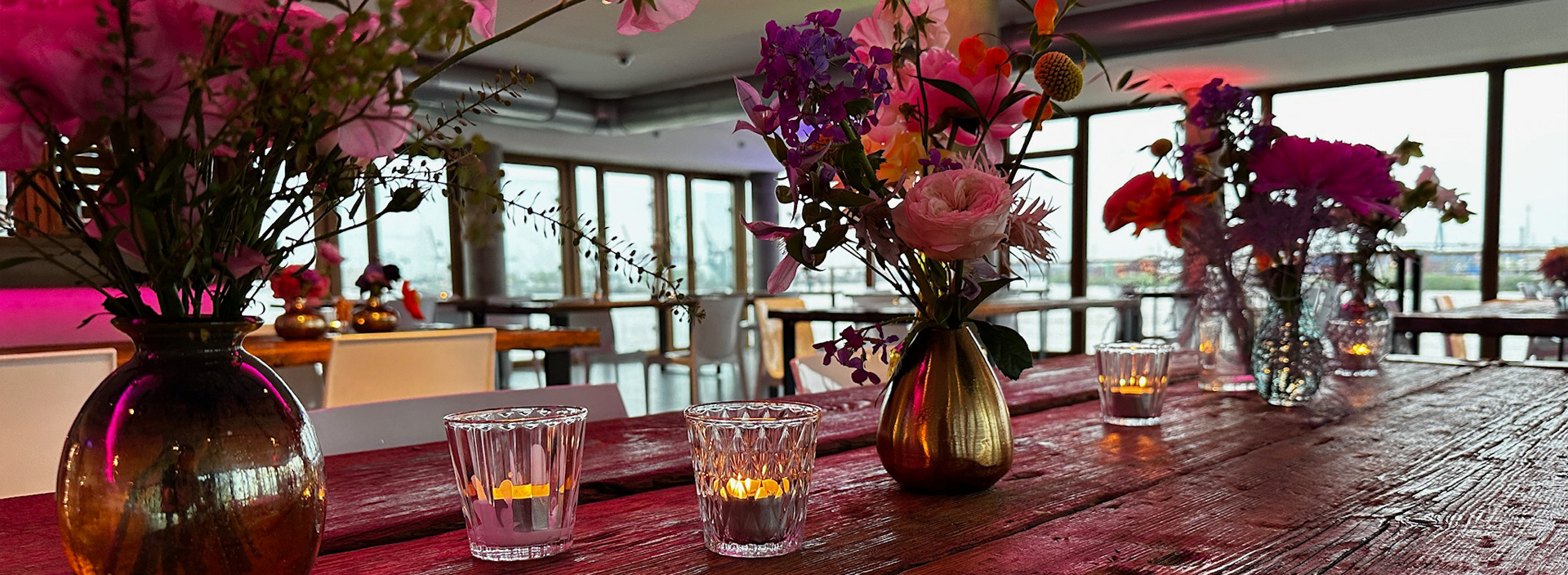 Ein Holztisch mit Teelichtern und verschiedenen Blumendekorationen