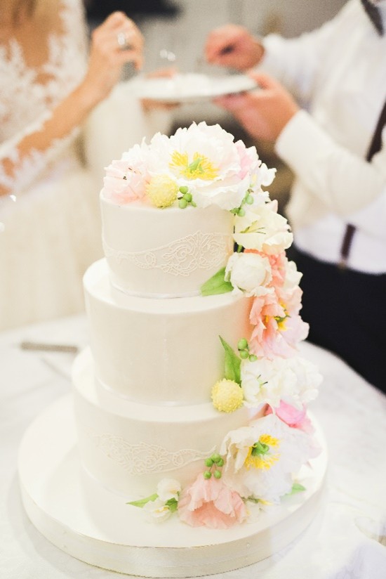 Ein Hochzeitstorte mit Ehepaar im Hintergrund
