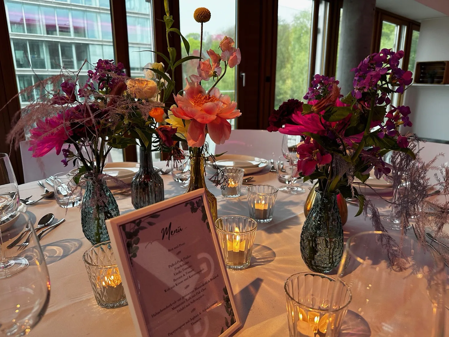 Festlich gedeckte Hochzeitstafel mit bunten Blumen und Menükarte